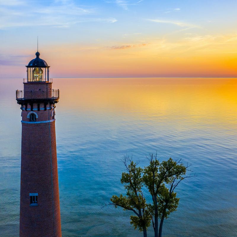 Close up view of Little Sable Point Lighthouse and ocean during sunset in Silver Lake State Park Michigan